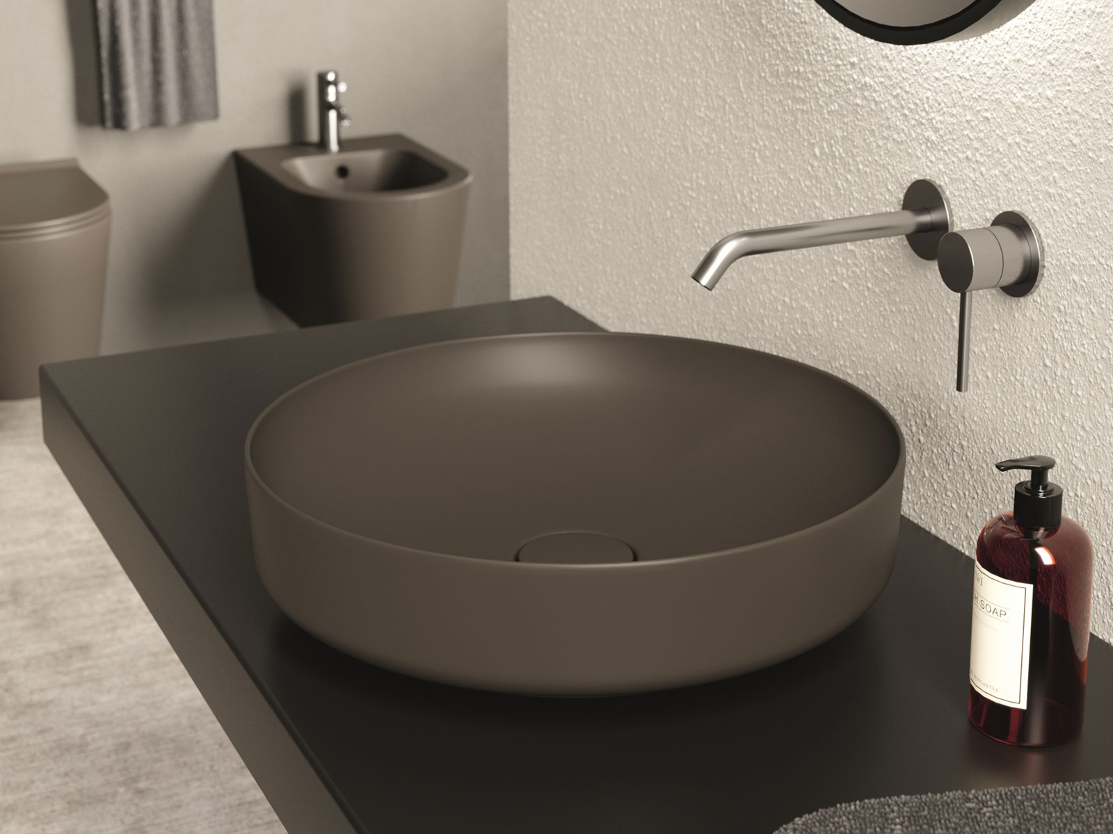 Miscelatore a parete in acciaio spazzolato sopra lavabo da appoggio tondo color fango su top scuro