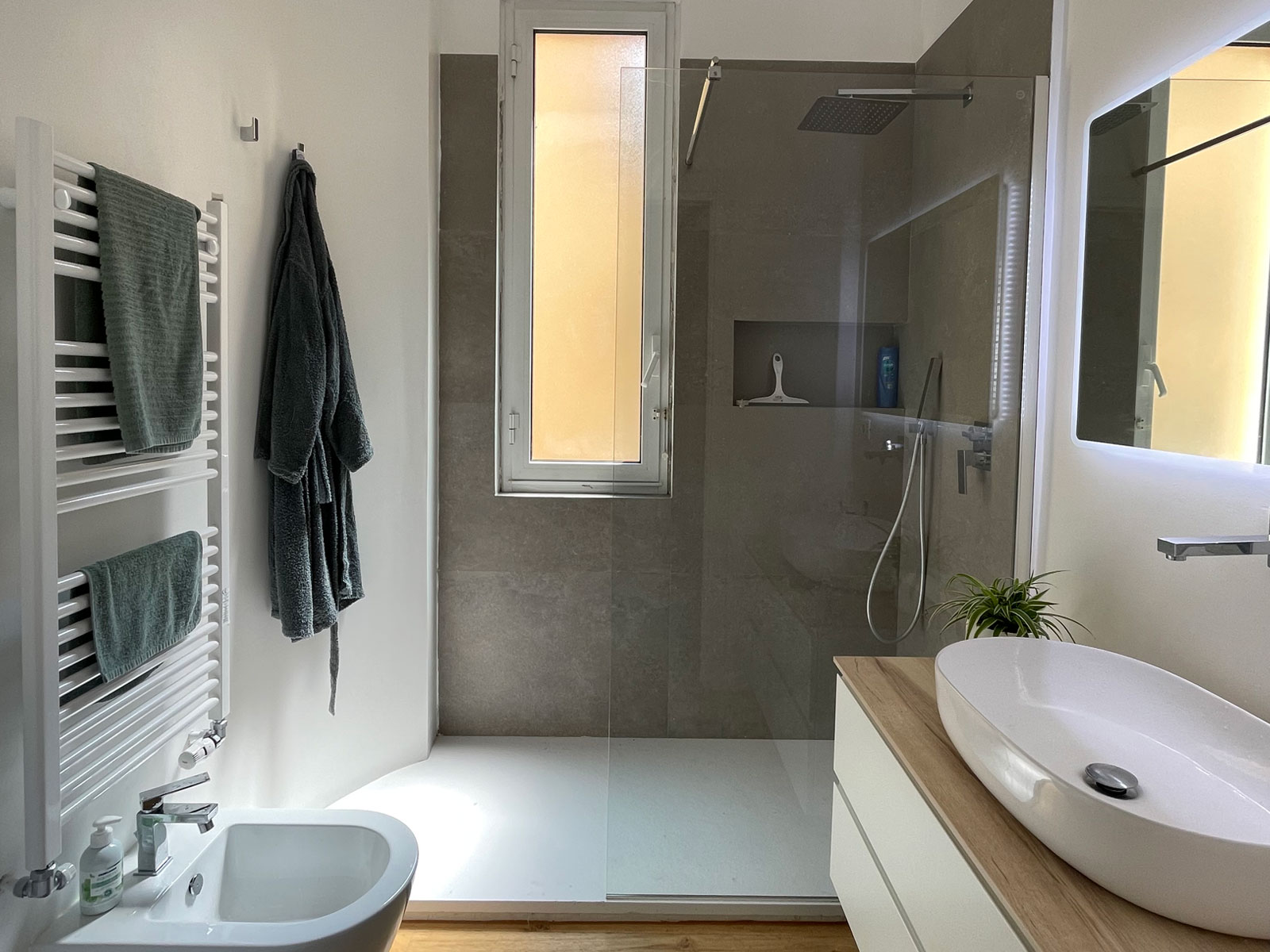Bagno con doccia walk-in in gres, mobile sospeso con top in legno e lavabo da appoggio