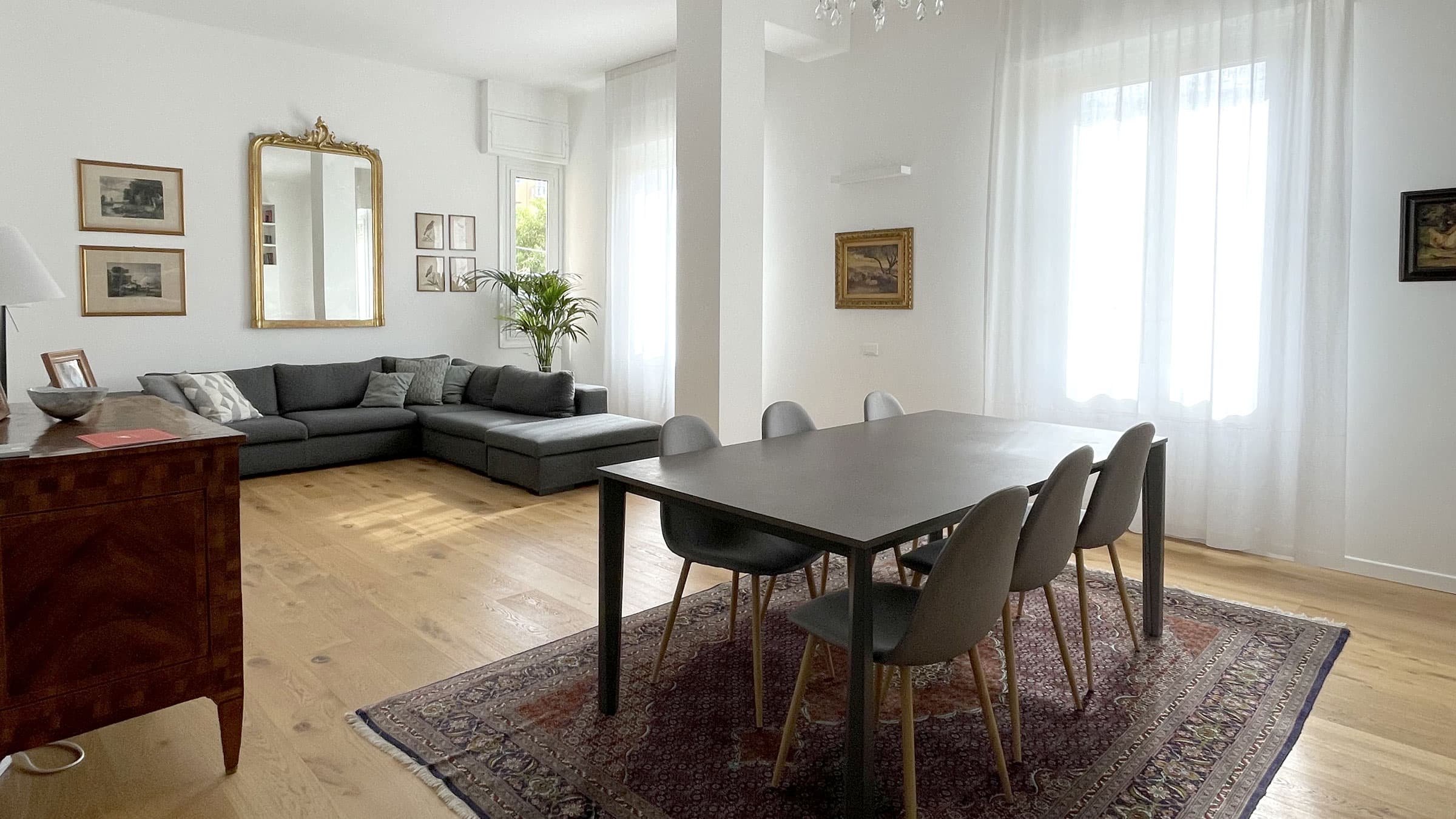 Soggiorno e zona pranzo con parquet in rovere nell'appartamento di Viale Cambiaso