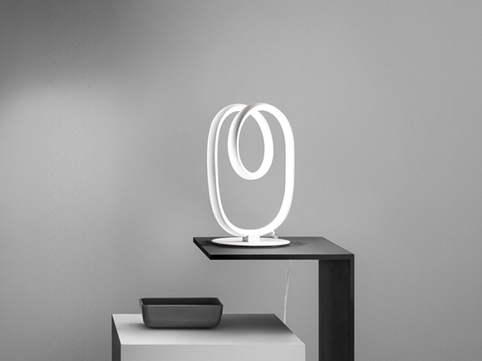 Lampada da tavolo LED bianca a nastro su tavolino nero