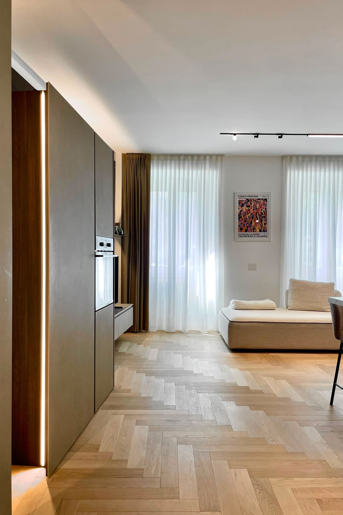 Colonne cucina con luce LED verticale, parquet a spina e soggiorno con tende a tutta altezza