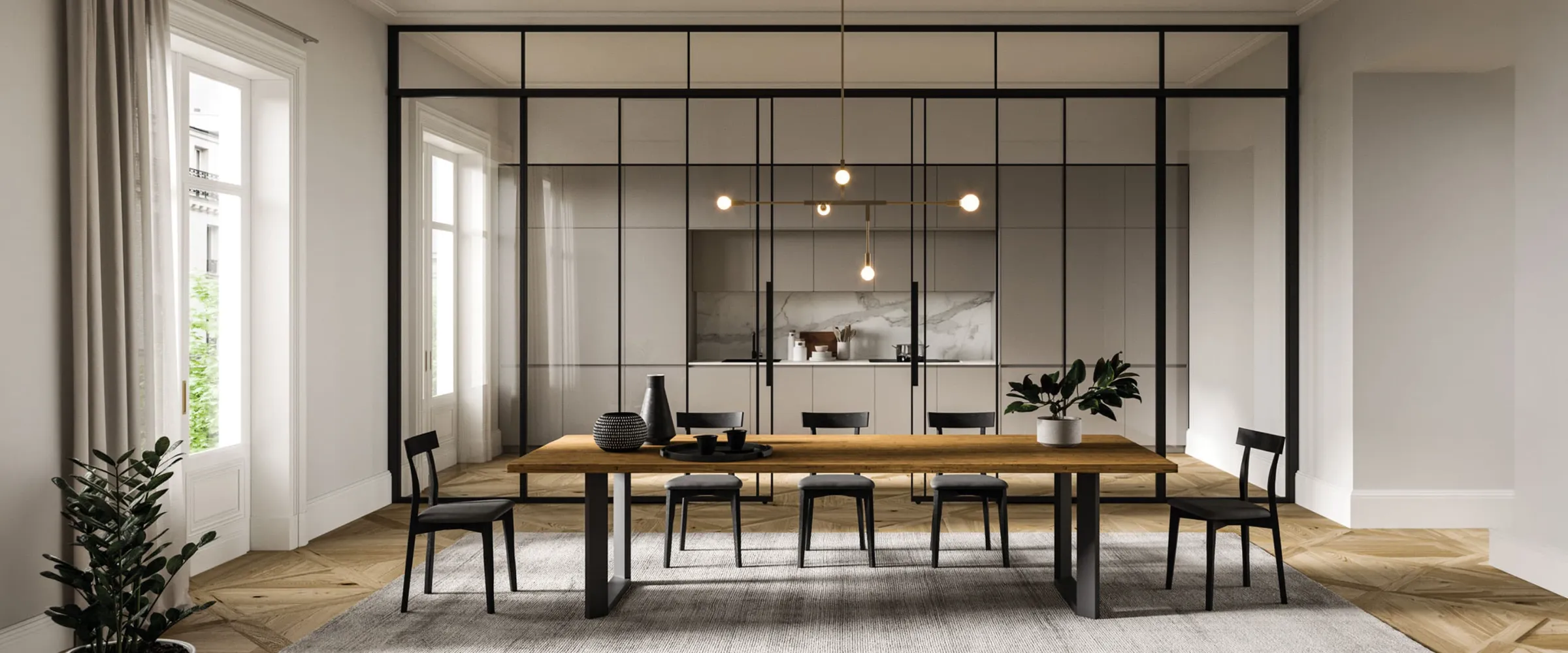 Zona pranzo con tavolo in legno davanti a una cucina separata da una vetrata con telaio nero, parquet a spina
