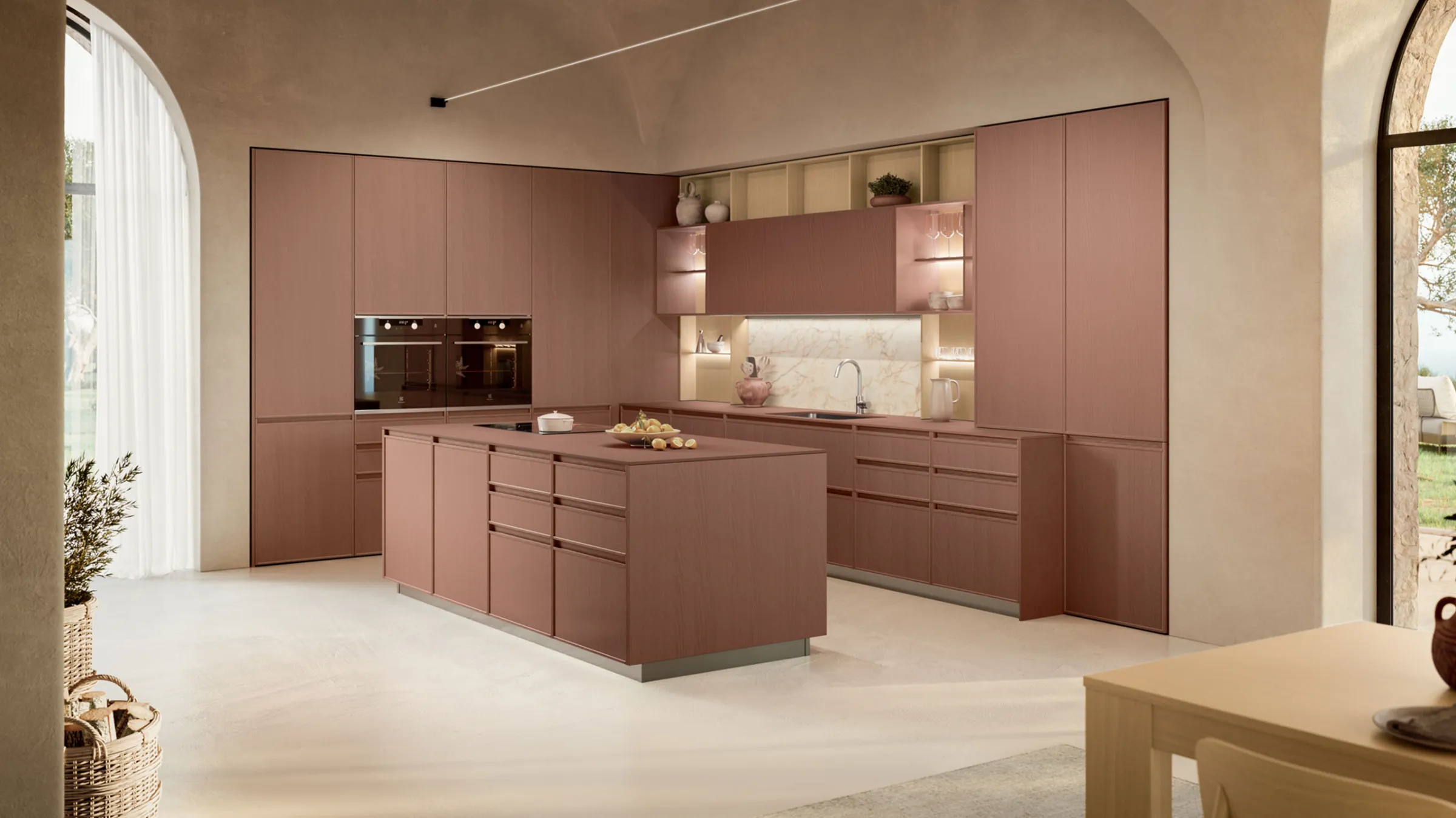 Cucina Sakura in legno rosa antico con isola e colonne a tutta altezza sotto una volta